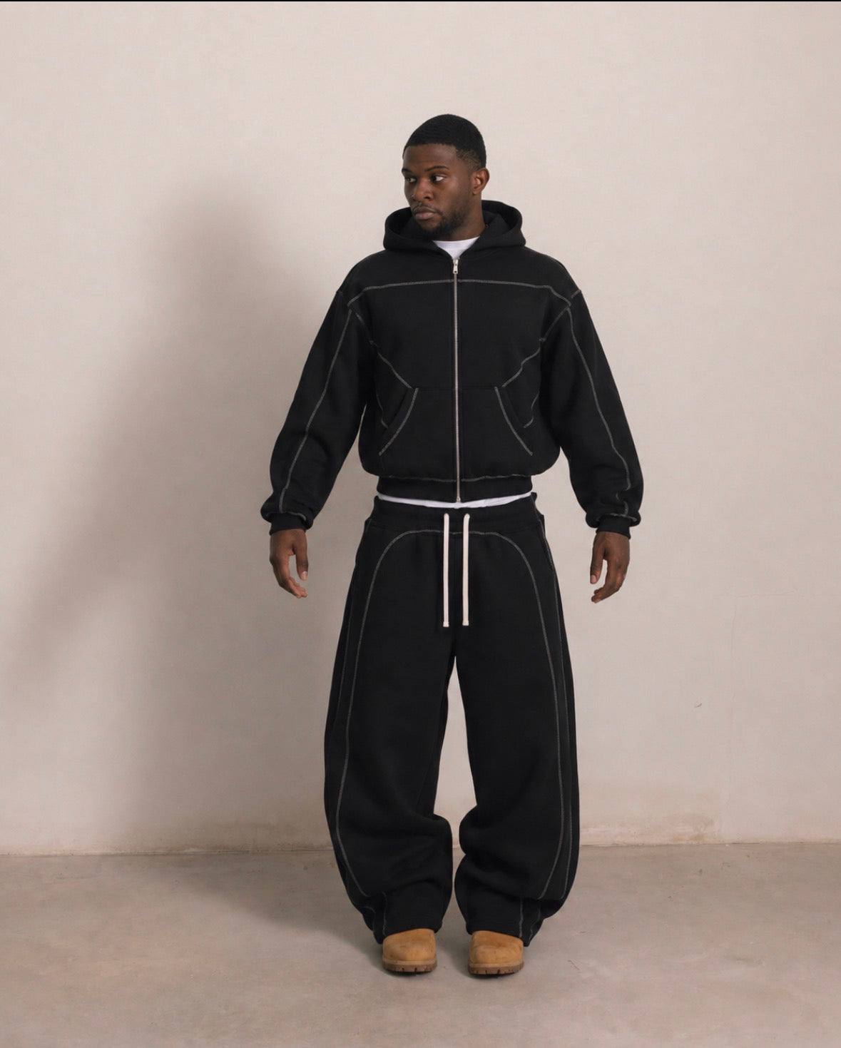 Black outer-stitched hoodie and sweatpants, front view