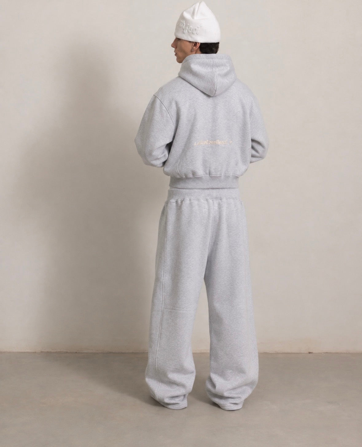 Grey hoodie and sweatpants, back view