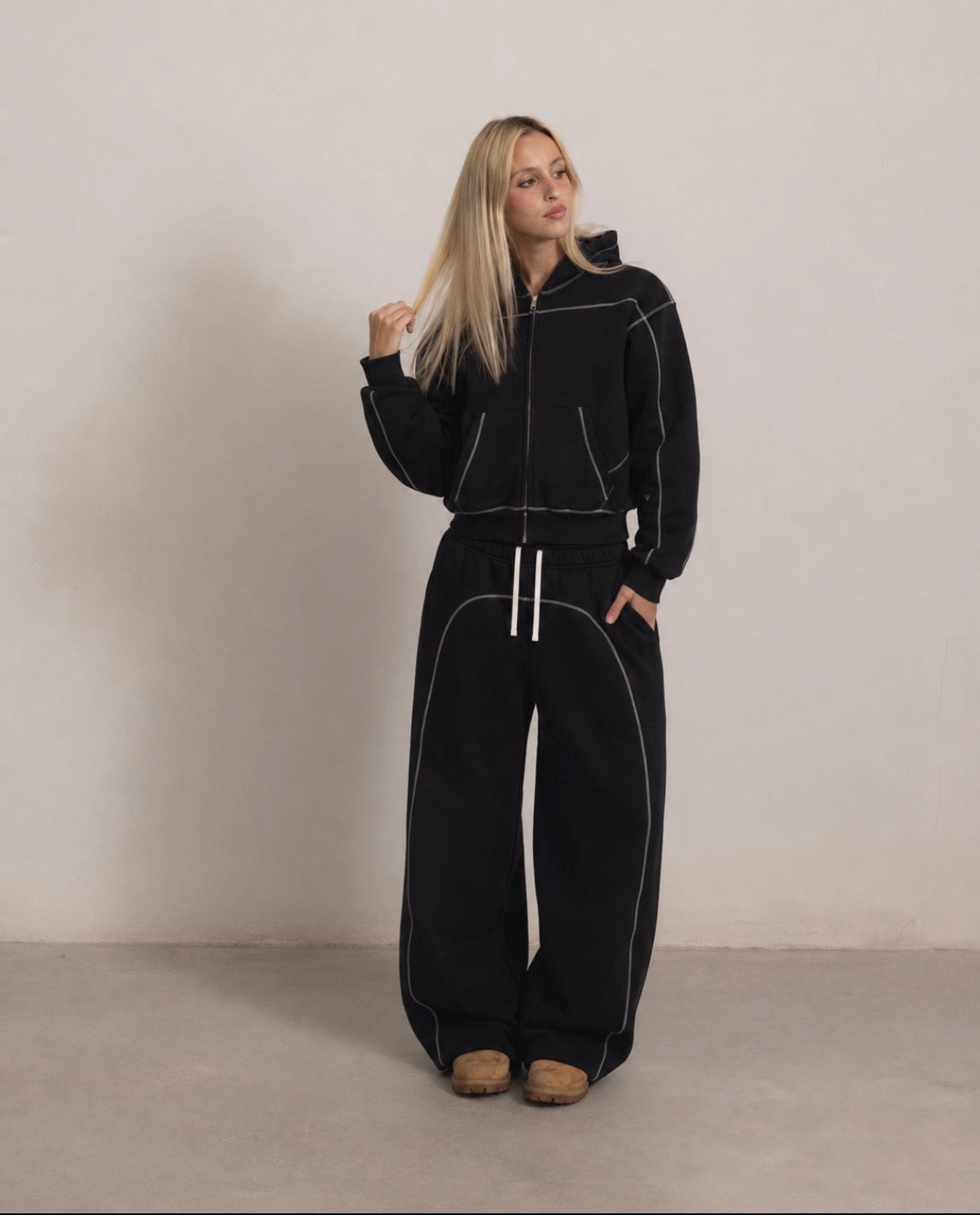 Black outer-stitched hoodie and sweatpants campaign look